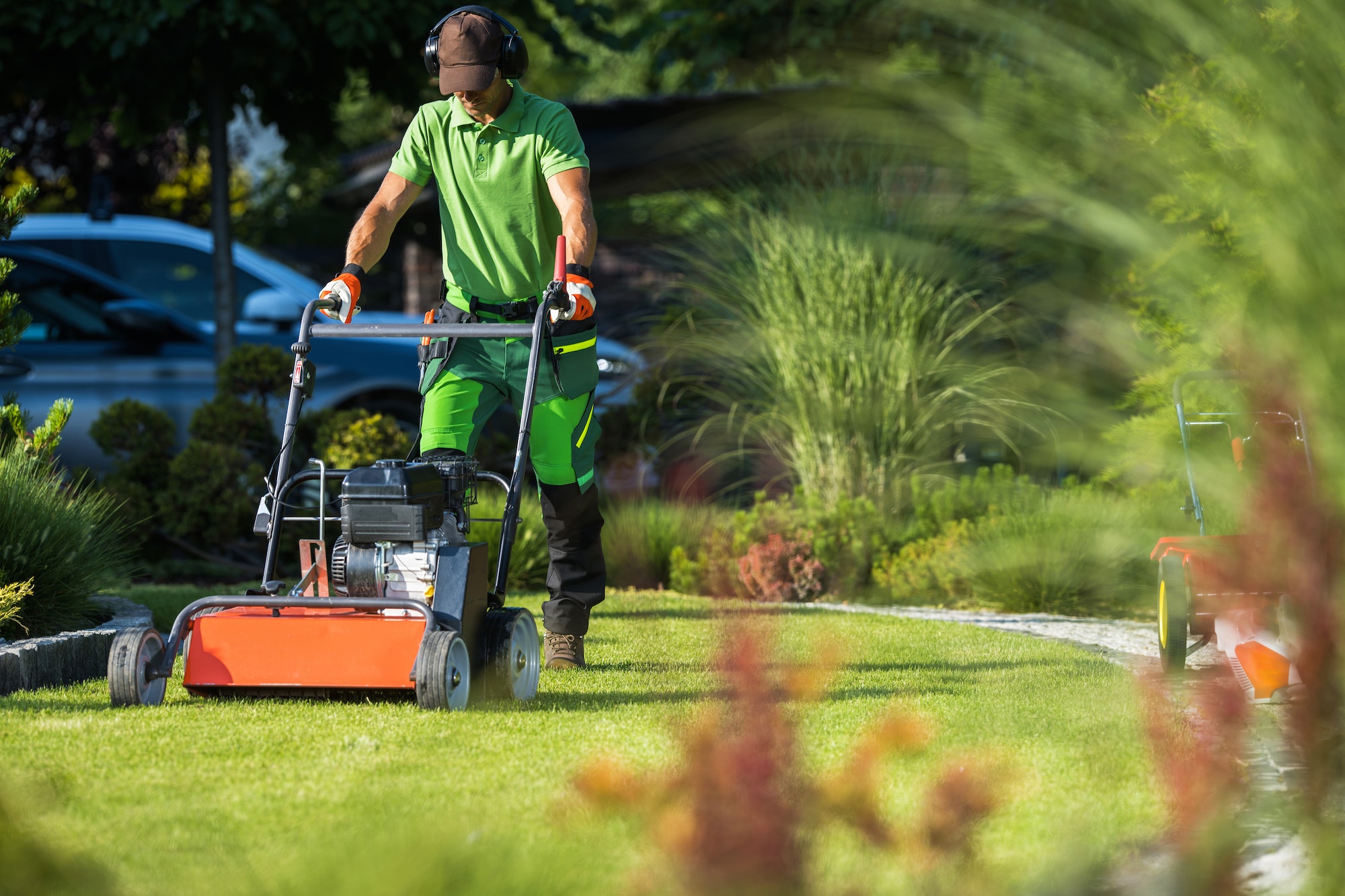 Landscaper with Scarifier Machine Taking Care of a Lawn.