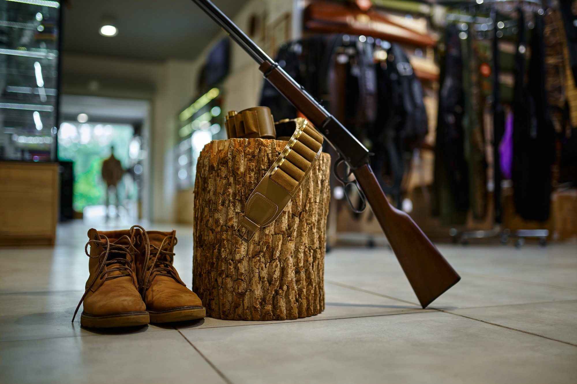 Rifle and hunting boots at the stump in gun store