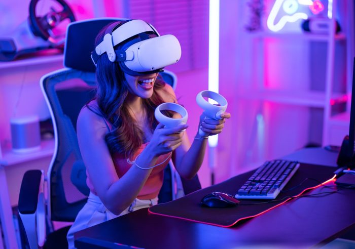 Asian young Esport woman gamer use technology VR glasses and play game.